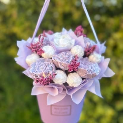 Hanging bouquet with pink and white roses, dusty miller, and dried florals in a pink box with purple ribbon