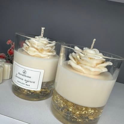 Two handmade soy candles with cream-colored wax, gold mica base, white twisted wicks, and dried flower tops in clear glass jars