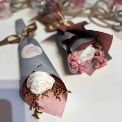 Decorative cone-shaped bouquets with white roses, pink flowers, and brown foliage arranged in pastel pink and gray paper wrapping